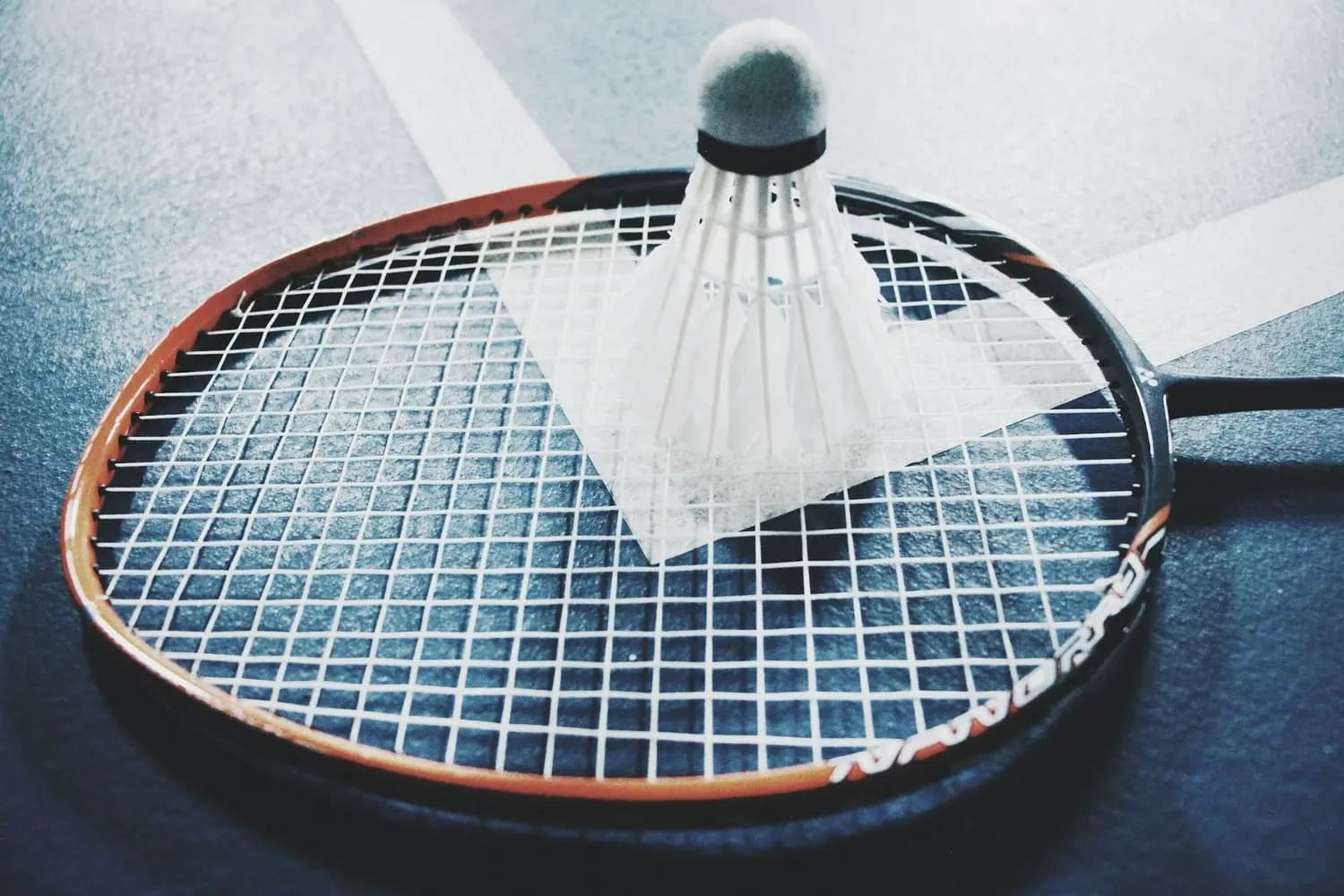 Rakieta badmintonowa z lotką leżąca na korcie