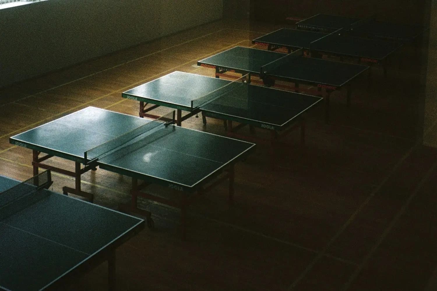 Kilka stołów do tenisa stołowego w sali sportowej